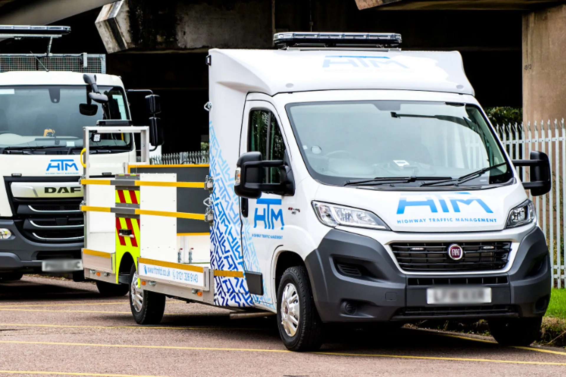 Two Highway Traffic Management trucks parked